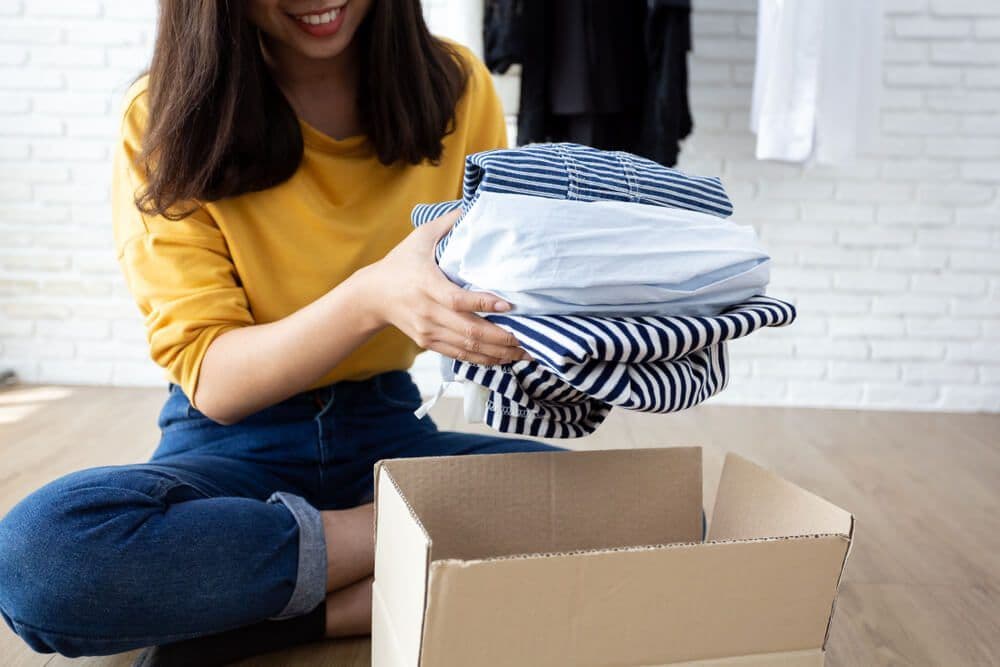Opgevouwen kleding ingepakt in een verhuisdoos
