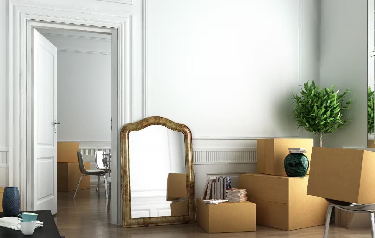 Lege kamer met enkele verhuisdozen bij het raam